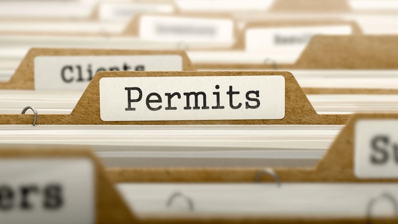 A close-up shot of a file folder with a label reading Permits in a filing cabinet, showcasing a variety of document categories