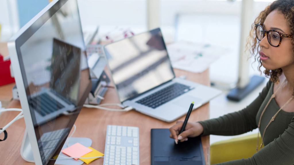 Girl searching for designs on computer screen representing graphic design business for women