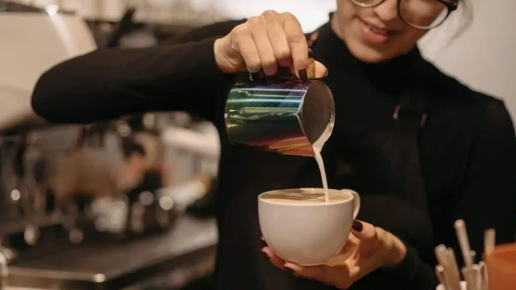 An employee pouring a cup of coffee