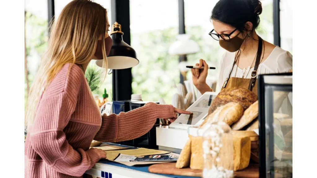 A customer interacting with an employee in a bakery